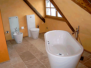 Badewanne und andere Sanitäreinrichtungen in einem Raum mit Dachschräge